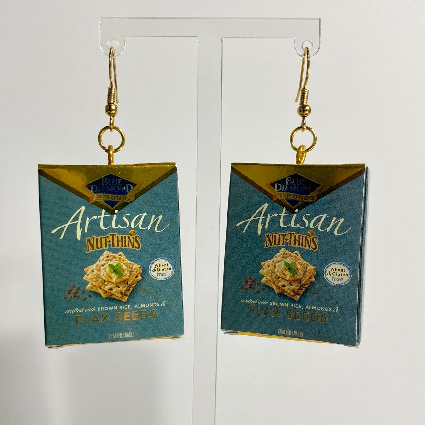 Mini gold Artisan Nut-Thin cracker box earrings on a white backdrop. 