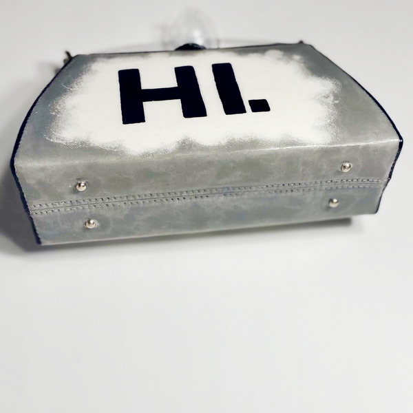 Bottom of purse with small silver pegs for purse to stand on. 