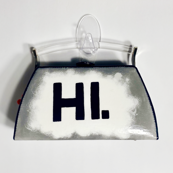 Box clutch with handpainted word, "hi", on a white background that fades into silver.