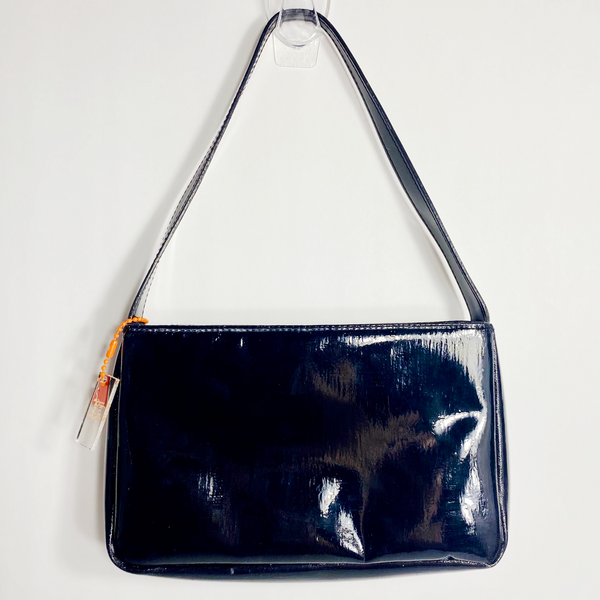 Black handbag on a white backdrop. 