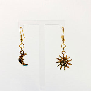 Haning earrings with a sun and moon charm in gold. 