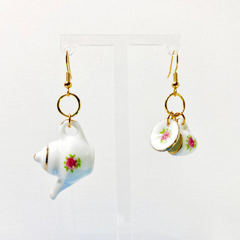 Hanging earrings with a teapot, teacup, and plate with floral decal accents. 